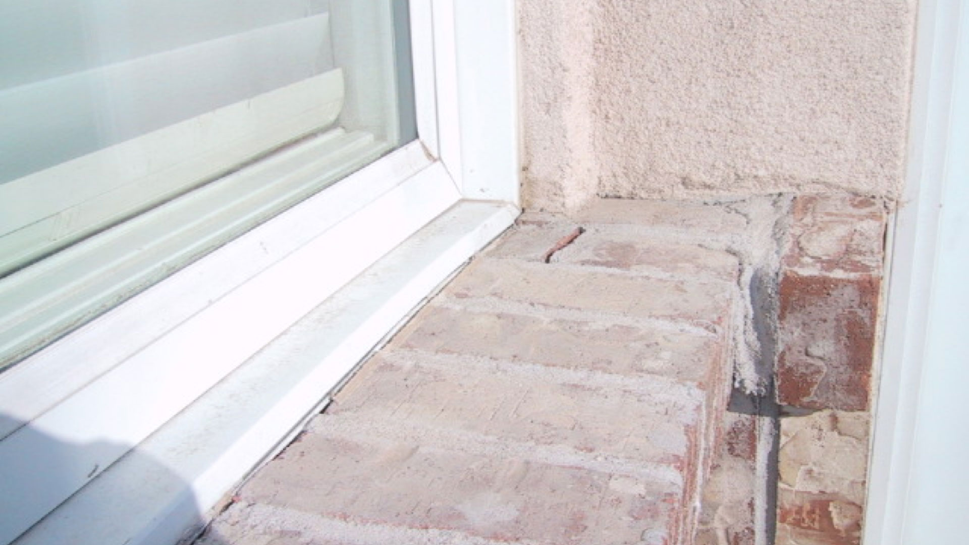 This 3rd floor brick sill was installed with a slope. Over time, the window moves downward along with the shrinking wood framing, and the brick veneer expands, pushing upward. Bricks that were tucked up under the window frame are rotate and crack in response to this movement. This 3rd floor brick sill was installed with a slope. Over time, the window moves downward along with the shrinking wood framing, and the brick veneer expands, pushing upward. Bricks that were tucked up under the window frame are rotate and crack in response to this movement.