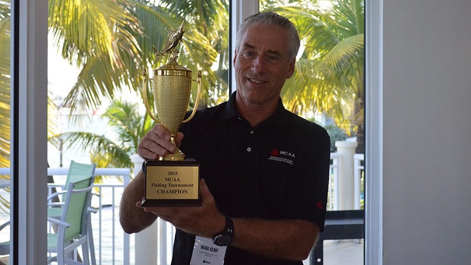 MCAA Chairman Mark Kemp, winner of the MCAA Fishing Tournament, poses with the championship trophy.