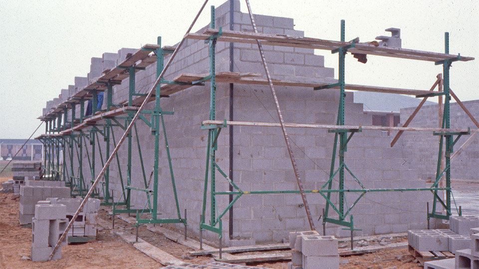 1981: Topping out an eight-inch block restaurant job on the Workhorse. Notice the speed poles set up on the corners. Ignore the lack of guardrails, etc. — this was before OSHA had made their first inspection in many areas.